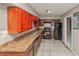 Functional kitchen featuring dark cabinetry, appliances, laminate countertops, and tile flooring at 2084 Snow Sw Rd, Atlanta, GA 30311