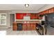 Functional kitchen featuring dark cabinetry, appliances, laminate countertops, and tile flooring at 2084 Snow Sw Rd, Atlanta, GA 30311
