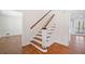 View of the staircase with hardwood floors, decorative front door, and white trim at 2938 Thornridge Dr, Atlanta, GA 30340