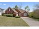 Charming brick home featuring a well-manicured lawn, red shutters, mature landscaping, and a spacious driveway at 625 Sycamore Glen Nw Ct, Lawrenceville, GA 30044