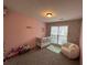 Bright Bedroom featuring a white crib, cozy chair, and a window overlooking the neighborhood at 903 Creek Bottom Rd, Loganville, GA 30052