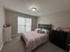 Well-lit bedroom featuring a comfortable bed, dresser, and a view of the outside at 903 Creek Bottom Rd, Loganville, GA 30052