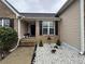 Home's entrance features stone landscaping, black shutters, and a cozy sitting bench on the covered porch at 903 Creek Bottom Rd, Loganville, GA 30052