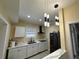 Kitchen with white cabinets, stainless steel appliances, and unique pendant lighting at 903 Creek Bottom Rd, Loganville, GA 30052