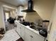 Galley kitchen with white cabinetry, modern black range hood, and laminate counter at 903 Creek Bottom Rd, Loganville, GA 30052
