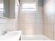 Simple bathroom featuring tiled walls, a vanity sink, and a shower-tub combo at 1126 Indale Sw Pl, Atlanta, GA 30310
