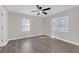 Light gray bedroom with vinyl floors, updated ceiling fan, and two large windows at 1729 Spring Ne St, Conyers, GA 30012