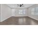 Open living room featuring hardwood floors, large windows, and a ceiling fan at 1729 Spring Ne St, Conyers, GA 30012