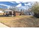 Brick home with separate garage and spacious backyard under a blue, cloudy sky at 1729 Spring Ne St, Conyers, GA 30012