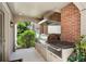 Covered outdoor kitchen with stainless steel grill and brick accents at 2525 Peachtree Ne Rd # 32, Atlanta, GA 30305