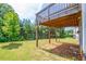 View of the backyard featuring a well-maintained lawn and supports for a deck above at 3540 Lindsy Brook, Douglasville, GA 30135