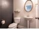 The powder room includes a pedestal sink, oval mirror, decorative shelf, and is painted in neutral tones at 3540 Lindsy Brook, Douglasville, GA 30135