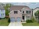 Traditional two-story home featuring a well-maintained lawn, brick facade, and two-car garage at 3540 Lindsy Brook, Douglasville, GA 30135