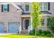 Inviting front entrance of brick home with a black door, sidelights, and well-kept garden at 3540 Lindsy Brook, Douglasville, GA 30135