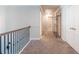 Spacious hallway features neutral walls, plush carpeting, and stylish wrought iron railing accents at 3540 Lindsy Brook, Douglasville, GA 30135