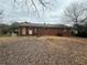 Brick house back exterior with door and windows overlooking yard covered in leaves on overcast day at 1789 Riverridge Nw Dr, Conyers, GA 30012