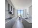 Modern kitchen with sleek gray cabinetry, stainless steel appliances, and a dining area with city views at 2425 Peachtree Nw Rd # 1802, Atlanta, GA 30305