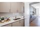 Butler's pantry featuring stainless steel sink, white countertops, neutral colored cabinets, and wood floors at 2425 Peachtree Nw Rd # 1802, Atlanta, GA 30305