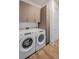 Functional laundry room featuring a full-size washer and dryer, ample storage cabinets and wood flooring at 2425 Peachtree Nw Rd # 1802, Atlanta, GA 30305
