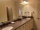 Bathroom featuring double sinks, granite counters, and large mirrors at 8440 Woodland Brooke Trl, Cumming, GA 30028