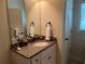 Bathroom with granite countertop, sink, mirror, and white cabinets, creating a clean and functional space at 8440 Woodland Brooke Trl, Cumming, GA 30028