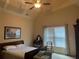 Bedroom with a tray ceiling, a ceiling fan, and large windows at 8440 Woodland Brooke Trl, Cumming, GA 30028