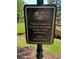 Community sign indicates fishing access for residents and guests, open dawn to dusk at 8440 Woodland Brooke Trl, Cumming, GA 30028