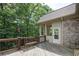 View of wooden deck, railing and exterior of house that backs to a lush wooded green backyard at 8440 Woodland Brooke Trl, Cumming, GA 30028