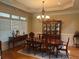 Elegant dining room with hardwood floors, a chandelier, and ample natural light from large windows at 8440 Woodland Brooke Trl, Cumming, GA 30028