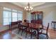 Formal dining room featuring a wooden table and chairs, hardwood floors, and a traditional chandelier at 8440 Woodland Brooke Trl, Cumming, GA 30028