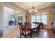 Dining room with hardwood floors, a chandelier, and views into the foyer at 8440 Woodland Brooke Trl, Cumming, GA 30028