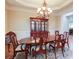 Dining area with a classic wooden table, chairs, and a chandelier creating an inviting atmosphere at 8440 Woodland Brooke Trl, Cumming, GA 30028