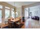 Dining room with natural light, hardwood floors, classic chandelier, and open access to the living room at 8440 Woodland Brooke Trl, Cumming, GA 30028