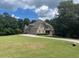 Spacious home featuring lush green lawn, mature trees and a circular driveway at 8440 Woodland Brooke Trl, Cumming, GA 30028