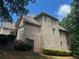 A sprawling two-story brick home sits on a lush green lot surrounded by mature trees at 8440 Woodland Brooke Trl, Cumming, GA 30028