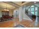 Elegant foyer with hardwood floors, a staircase, and an open dining area offering a grand entrance at 8440 Woodland Brooke Trl, Cumming, GA 30028