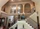 Grand foyer with a staircase, wood railings, and a view of the second floor at 8440 Woodland Brooke Trl, Cumming, GA 30028