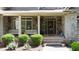 Inviting front porch with brick and stone accents, perfect for relaxing outdoors at 8440 Woodland Brooke Trl, Cumming, GA 30028
