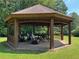 Community gazebo with picnic table and seating, perfect for relaxing and enjoying the natural surroundings at 8440 Woodland Brooke Trl, Cumming, GA 30028