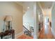 Elegant hallway with hardwood floors, decorative columns, and an open staircase leading to the lower level at 8440 Woodland Brooke Trl, Cumming, GA 30028