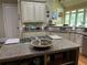 Kitchen features a center island with a built-in gas cooktop and granite countertops at 8440 Woodland Brooke Trl, Cumming, GA 30028