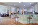 Spacious kitchen with bar seating, granite countertops, and open floor plan to the living area at 8440 Woodland Brooke Trl, Cumming, GA 30028