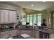 Spacious kitchen featuring stainless steel appliances, granite countertops and adjacent to the deck at 8440 Woodland Brooke Trl, Cumming, GA 30028