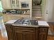Spacious kitchen island with granite countertop, cooktop and cabinet storage at 8440 Woodland Brooke Trl, Cumming, GA 30028