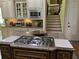 Gourmet kitchen featuring a large center island with cooktop, custom cabinets, and stainless steel appliances at 8440 Woodland Brooke Trl, Cumming, GA 30028
