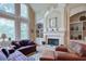 Spacious living room with fireplace, built-in bookshelves, and many windows at 8440 Woodland Brooke Trl, Cumming, GA 30028