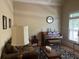 Cozy living room with a piano, hardwood floors and a large window that provides natural light at 8440 Woodland Brooke Trl, Cumming, GA 30028