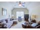 Cozy living room with comfortable seating, soft carpet, and a ceiling fan for added comfort at 8440 Woodland Brooke Trl, Cumming, GA 30028
