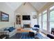 Vaulted living room with fireplace, built-in shelving, large windows, and natural light at 8440 Woodland Brooke Trl, Cumming, GA 30028