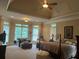Spacious main bedroom showcasing trey ceilings, neutral walls, a ceiling fan, and large windows at 8440 Woodland Brooke Trl, Cumming, GA 30028